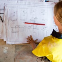 a female construction worker looks at site plans - home decoration fotografías e imágenes de stock