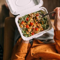 a from above shot of an unrecognizable female sitting and eating some healthy colourful food from her lunchbox - junk food stock pictures, royalty-free photos & images