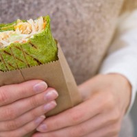 a girl eats a vegetarian vegetable shawarma on the street. fast food. lavash, burrito, roll in the hands of a woman. - junk food stock pictures, royalty-free photos & images