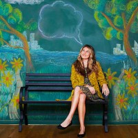 a girl is sitting on a park bench thinking. - garden decoration photos et images de collection