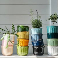 a group of multicolored ceramic planters stacked on the dresser. - garden decoration stock pictures, royalty-free photos & images