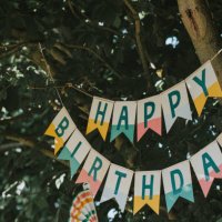 a 'happy birthday' banner hangs from a tree - garden decoration stock pictures, royalty-free photos & images