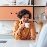 a happy couple drinking tea in the kitchen, talking and laughing - coffee stock pictures, royalty-free photos & images