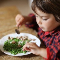 a little boy eating peas for the lunch - food stock pictures, royalty-free photos & images