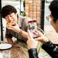 a man has a friend take a picture of him eating pizza on vacation with his smartphone. - food stock pictures, royalty-free photos & images