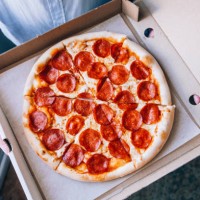 a man holding a pizza box. close-up - junk food stock pictures, royalty-free photos & images