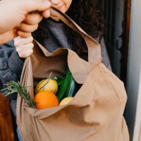 a man is delivering a bag of vegetables and fruit - food stock pictures, royalty-free photos & images