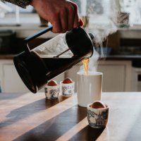 a man pours a cup of coffee from a french press coffee maker - coffee stock pictures, royalty-free photos & images