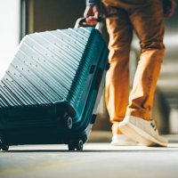 a man walks down the hotel corridor with luggage. - travel stock pictures, royalty-free photos & images