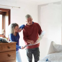 a mature couple looking at a paint colour chart - home decoration stock pictures, royalty-free photos & images