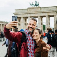 a mature couple take a selfie together in front of brandenburg gate in berlin - travel stockfoto's en -beelden