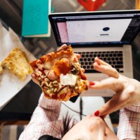 a middle-aged woman sitting in the kitchen at the glass table - junk food stock pictures, royalty-free photos & images