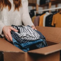 a millennial woman is preparing the shipment of some clothes in her new online shop - fashion stock pictures, royalty-free photos & images