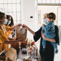 a mother with her little son is taking a bag of food at the food and clothes bank - food stock pictures, royalty-free photos & images