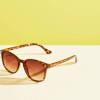 a pair of sunglasses against a yellow background - fashion stock pictures, royalty-free photos & images