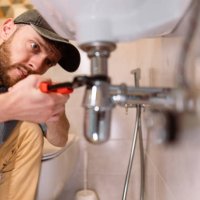 a plumber carefully fixes a leak in a sink using a wrench - home decoration stock pictures, royalty-free photos & images