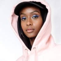 a portrait of a beautiful, young muslim woman wearing a black hijab, black baseball cap and a pink hoodie photographed in studio setting. - fashion stock pictures, royalty-free photos & images