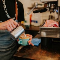 a professional barista makes a coffee in a cafe - coffee stock pictures, royalty-free photos & images