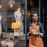 a small business owner stands outside her handbag shop. - fashion stock pictures, royalty-free photos & images