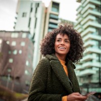 a smiling young woman at the downtown district - fashion stock pictures, royalty-free photos & images
