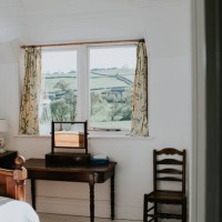 a stylish, tidy bedroom painted white, with a beautiful countryside view - home decoration stock-fotos und bilder