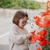 a toddler girl in a stylish outfit with purple glasses on a floral background - fashion stock pictures, royalty-free photos & images