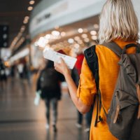 a woman at the airport holding a passport with a boarding pass - travel stock pictures, royalty-free photos & images