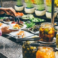a woman chooses food in a hotel restaurant. a woman takes food from the buffet. - junk food stock pictures, royalty-free photos & images