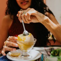 a woman enjoys a refreshing lemon sorbet, served in a frozen lemon - food stock pictures, royalty-free photos & images