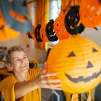 a woman hanging a jack o' lantern halloween decoration - home decoration stock pictures, royalty-free photos & images