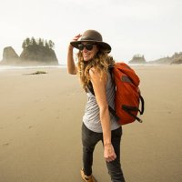 a woman hiking along a remote beach. - travel stock pictures, royalty-free photos & images