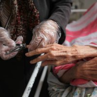 a woman is cutting nail of old woman - nails art stock pictures, royalty-free photos & images