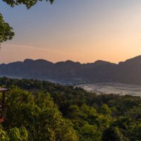 a woman standing at phi phi view point and see the view from a bird's eye view of the mountains, the sea and the sunset. and town on phi phi island, krabi province, thailand - travel stock pictures, royalty-free photos & imag