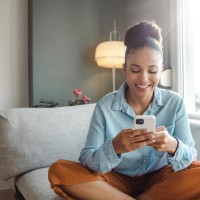 a young beautiful woman using a smart phone at home - home decoration stock pictures, royalty-free photos & images