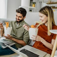 a young couple is working from home and eating pasta - junk food stock pictures, royalty-free photos & images