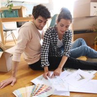 a young couple looking at plans of their new home - home decoration stock pictures, royalty-free photos & images