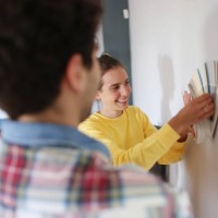 a young couple picking paint colors for new home - home decoration stockfoto's en -beelden