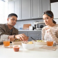 a young latinx brother and sister enjoy eating a mexican salad bowl at the kitchen table, wearing casual clothing. - junk food stock pictures, royalty-free photos & images