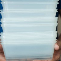 a young man is holding a recyclable plastic food container on a white background - junk food stock pictures, royalty-free photos & images