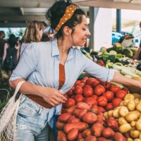 a young woman buys vegetables and fruits at the market . - food stock pictures, royalty-free photos & images