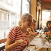 a young woman eating in a restaurant - food stock pictures, royalty-free photos & images