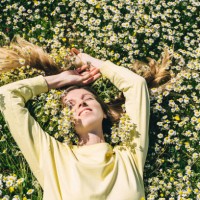 a young woman in a yellow sweater lies in a field of daisies, top view. - fashion stock pictures, royalty-free photos & images