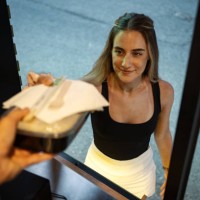 a young woman is picking up takeaway food from a food truck - junk food stock pictures, royalty-free photos & images