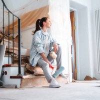 a young woman joyfully sits against the background of repairs in the house - home decoration stock pictures, royalty-free photos & images