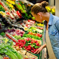 a young woman looking at fresh vegetables in the supermarket - food stock pictures, royalty-free photos & images