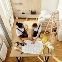 above view of manual workers analyzing blueprints in moving apartment. - home decoration stock pictures, royalty-free photos & images