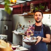 action portrait of male chef tossing ingredients in bowl - food stock pictures, royalty-free photos & images