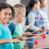 adorable little girl smiles for camera while playing xylophone - concert stock pictures, royalty-free photos & images