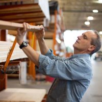 adult male customer in hardware store choosing lumber - home decoration stock pictures, royalty-free photos & images