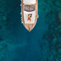 aerial drone view of couple in love on board of luxury yacht anchored in tropical paradise bay with emerald clear water - travel stock pictures, royalty-free photos & images